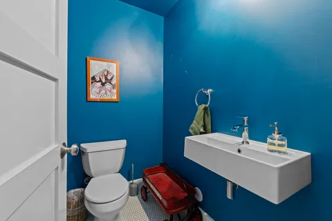 a bathroom with a toilet a sink and mirror