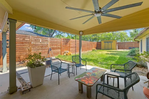 a view of a patio with table and chairs under an umbrella