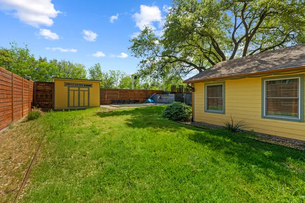 a view of a house with backyard and a tree
