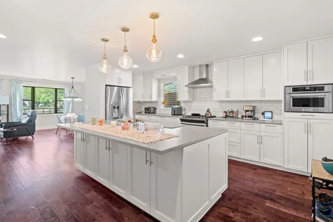 a kitchen with cabinets a sink a center island and wooden floor