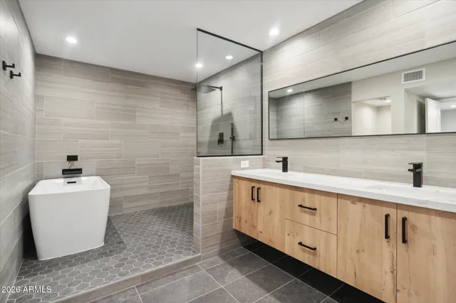 a bathroom with a sink a toilet a mirror and shower