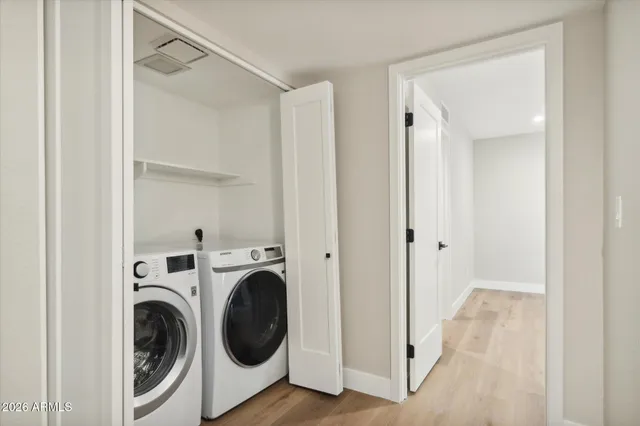 an empty room with wooden floor ceiling fan and windows