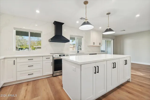 a kitchen that has a lot of cabinets in it and wooden floors