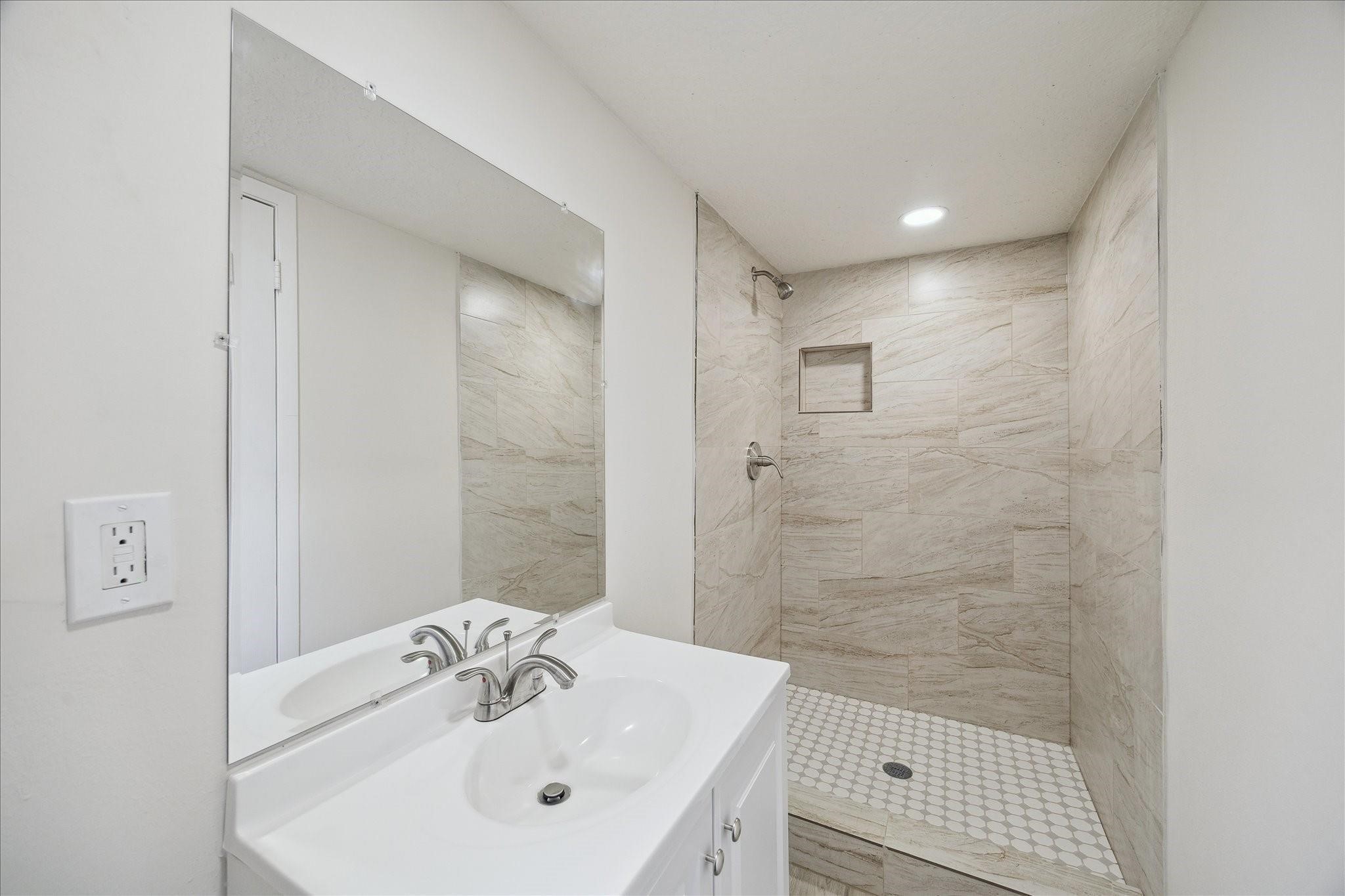 5515 Knightwood Street Houston, TX 77016 - Photo 10 of 11 a bathroom with a sink a shower and a mirror