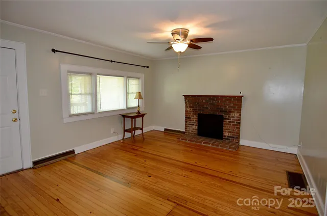 a view of an empty room with a fireplace and a window