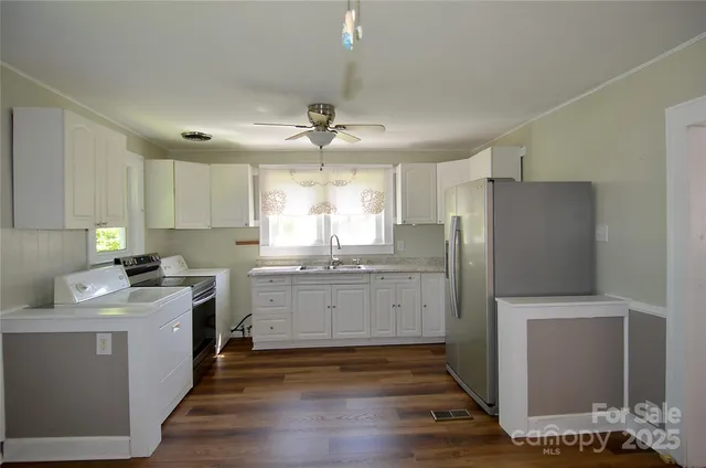 a kitchen with a refrigerator sink and cabinets