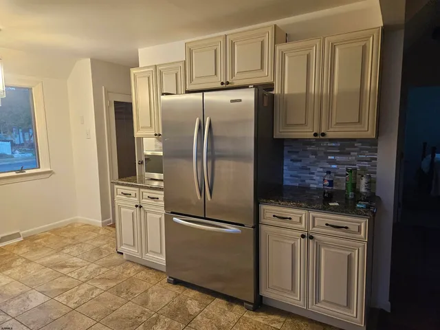 a kitchen with stainless steel appliances granite countertop a refrigerator a stove a sink and dishwasher