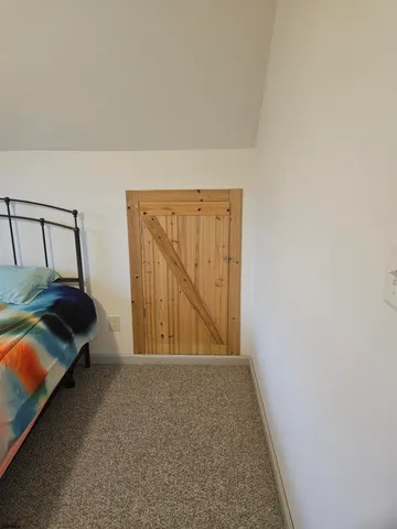 a bed sitting in a bedroom next to a window