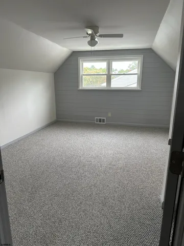 an empty room with a window and a ceiling fan