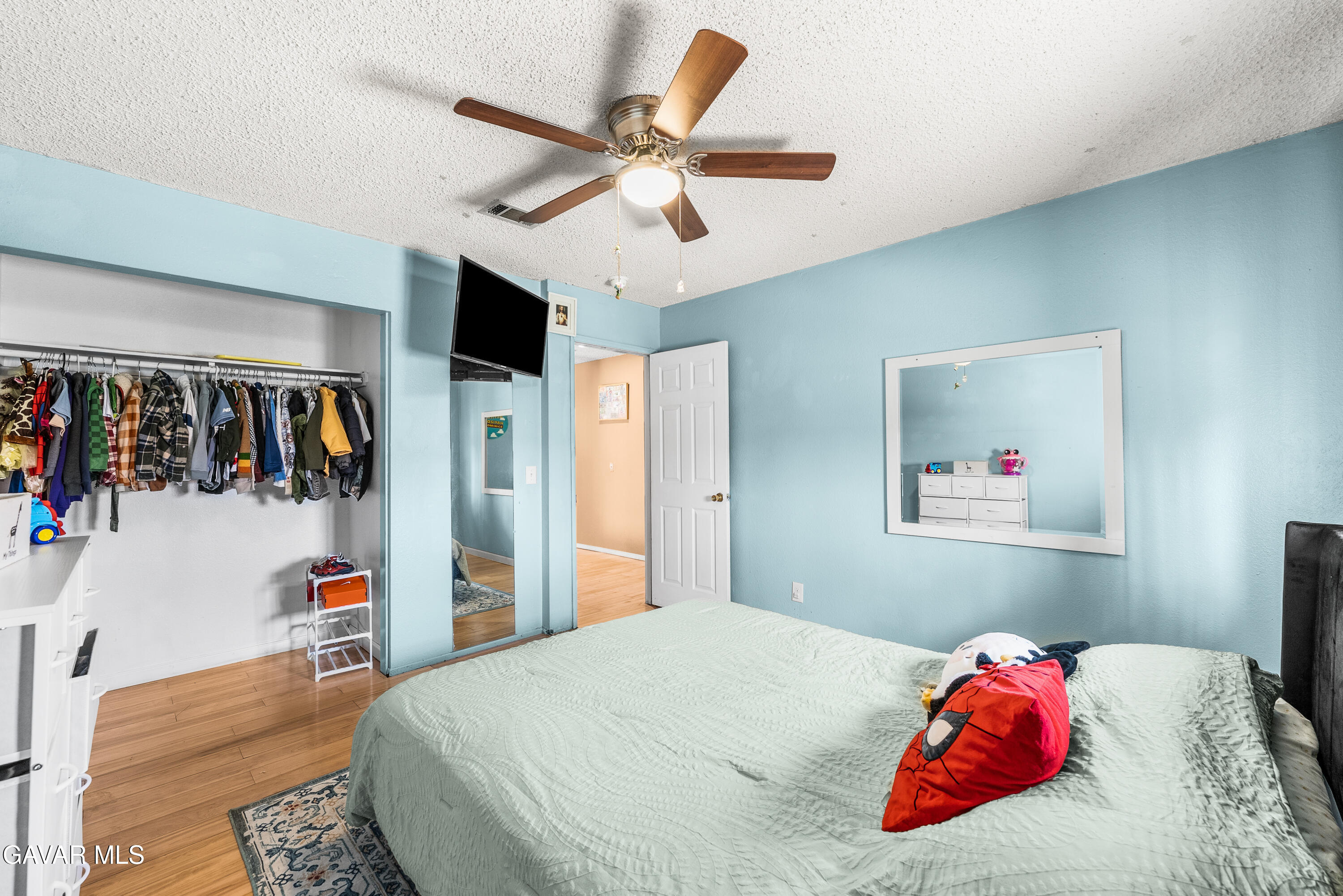 43903 11th Street East Lancaster, CA 93535 - Photo 37 of 45 a bedroom with a large bed and a chandelier