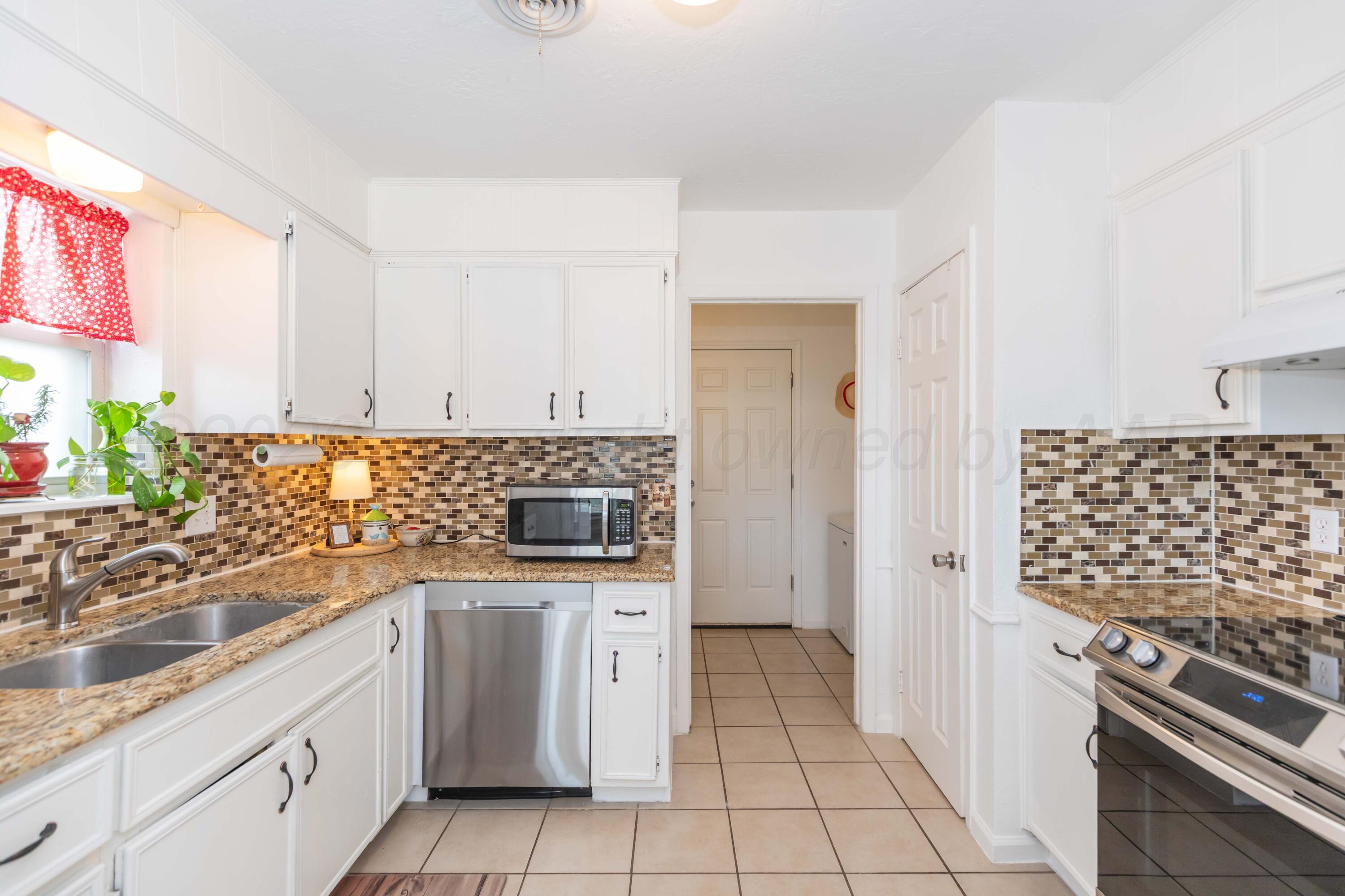 7308 Holyoke Trail Amarillo, TX 79121 - Photo 12 of 39 a kitchen with white cabinets and appliances