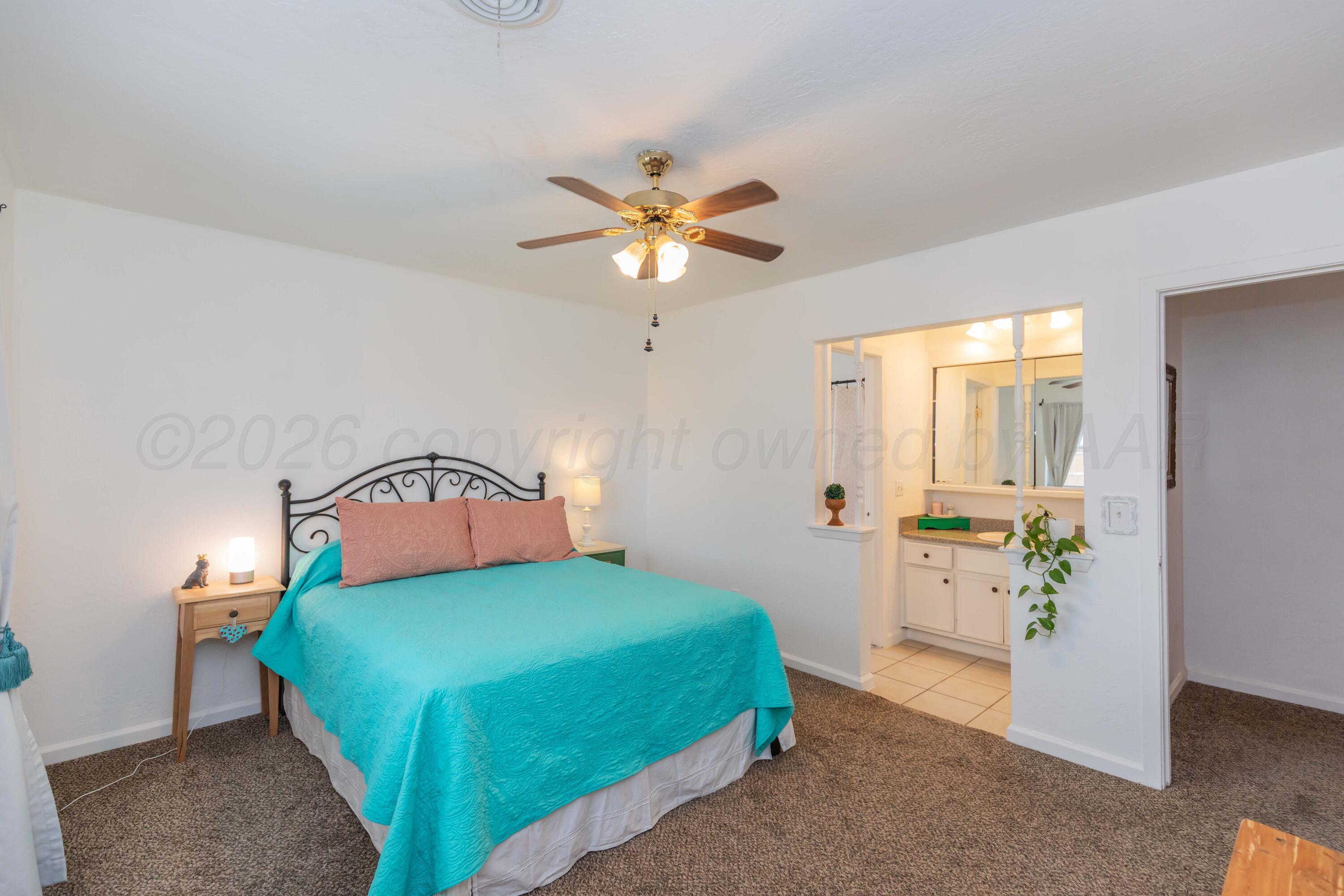 7308 Holyoke Trail Amarillo, TX 79121 - Photo 18 of 39 a bedroom with a bed and a chandelier
