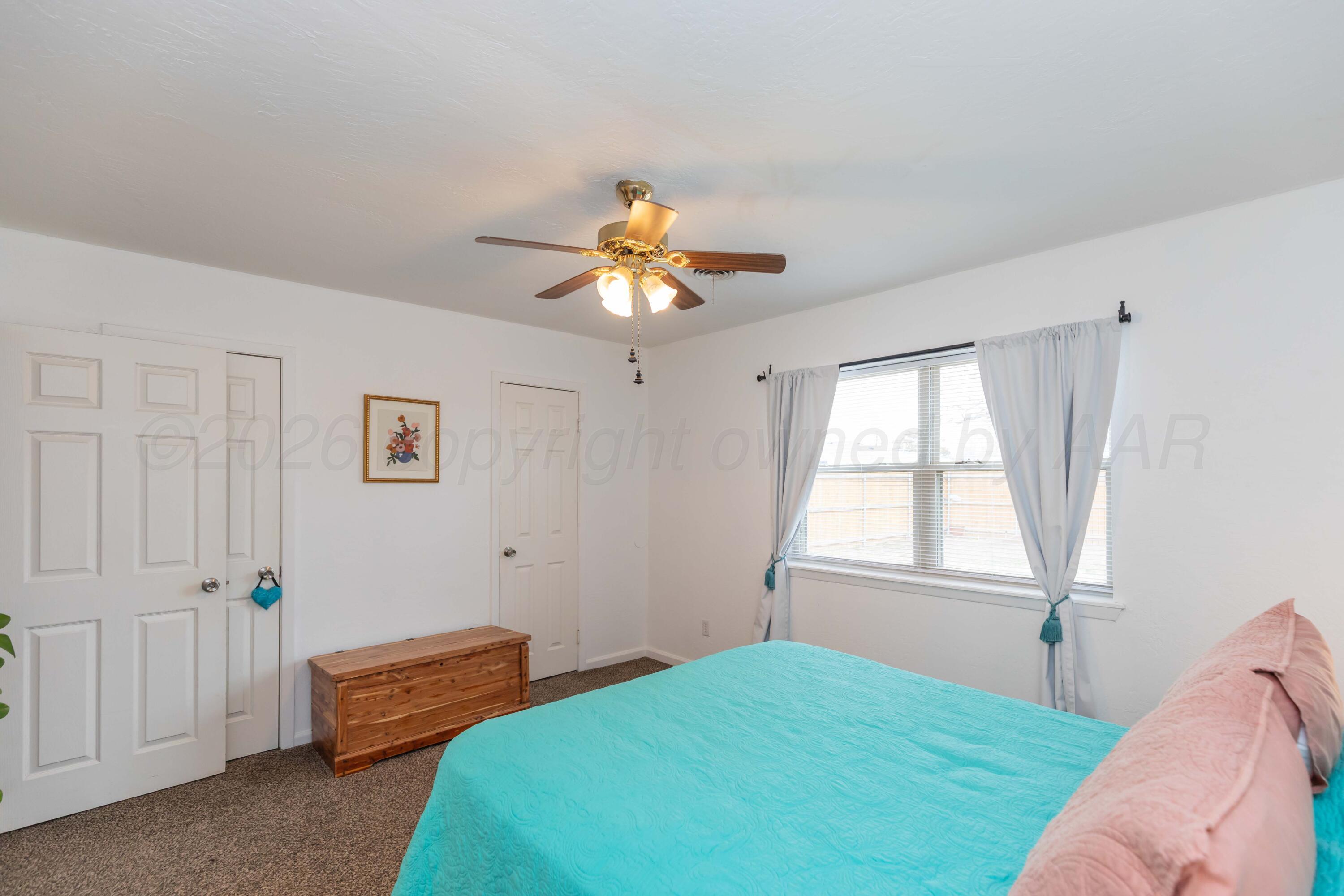 7308 Holyoke Trail Amarillo, TX 79121 - Photo 20 of 39 a bedroom with a bed and a chandelier fan