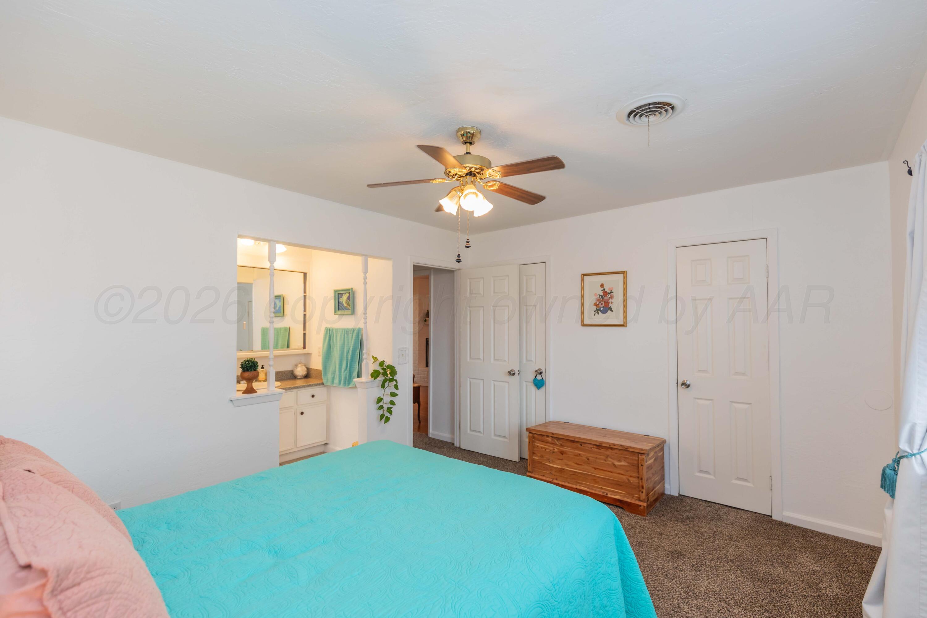 7308 Holyoke Trail Amarillo, TX 79121 - Photo 21 of 39 a bedroom with a bed and a chandelier
