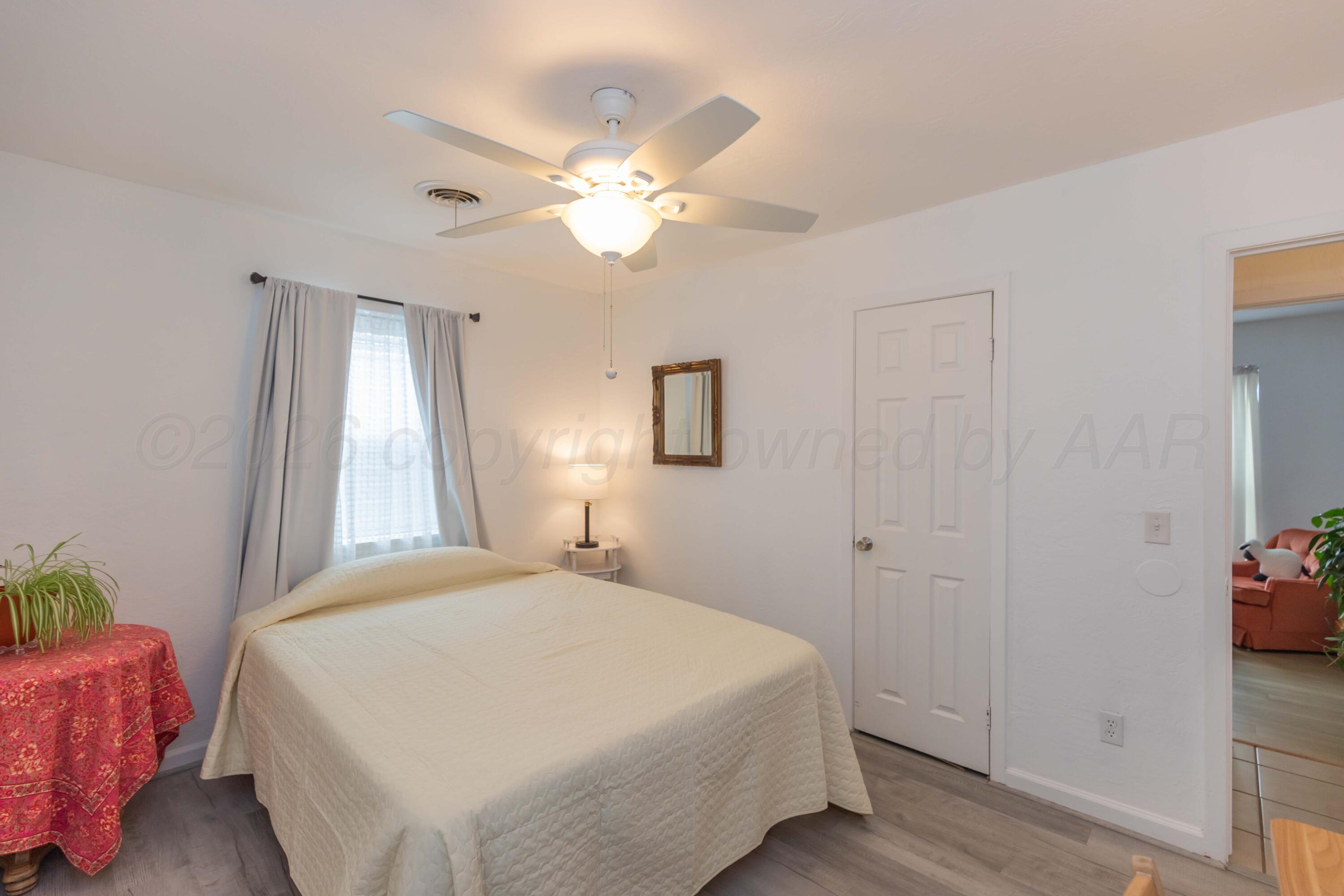 7308 Holyoke Trail Amarillo, TX 79121 - Photo 31 of 39 a bedroom with a bed and a chandelier