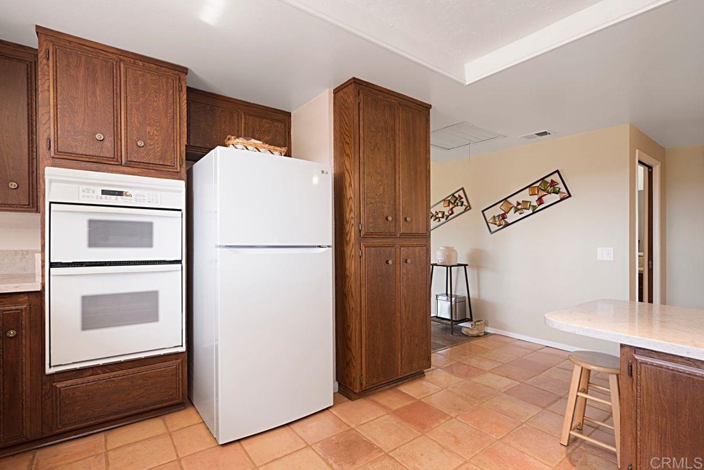 29573 Miller Road Valley Center, CA 92082 - Photo 13 of 37 a white refrigerator freezer and a stove sitting inside of a kitchen