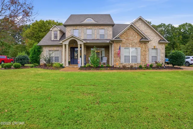 a living room with furniture a fireplace and a large window