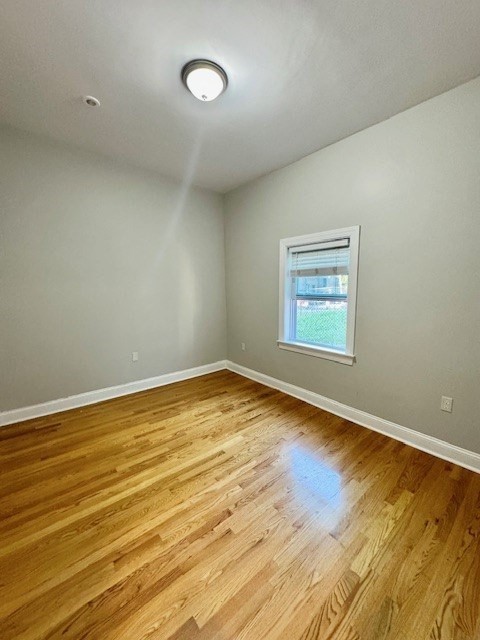 6 St James Place, Unit 6 Boston, MA 02119 - Photo 13 of 18 an empty room with wooden floor and windows