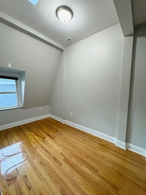 6 St James Place, Unit 6 Boston, MA 02119 - Photo 14 of 18 an empty room with wooden floor and windows