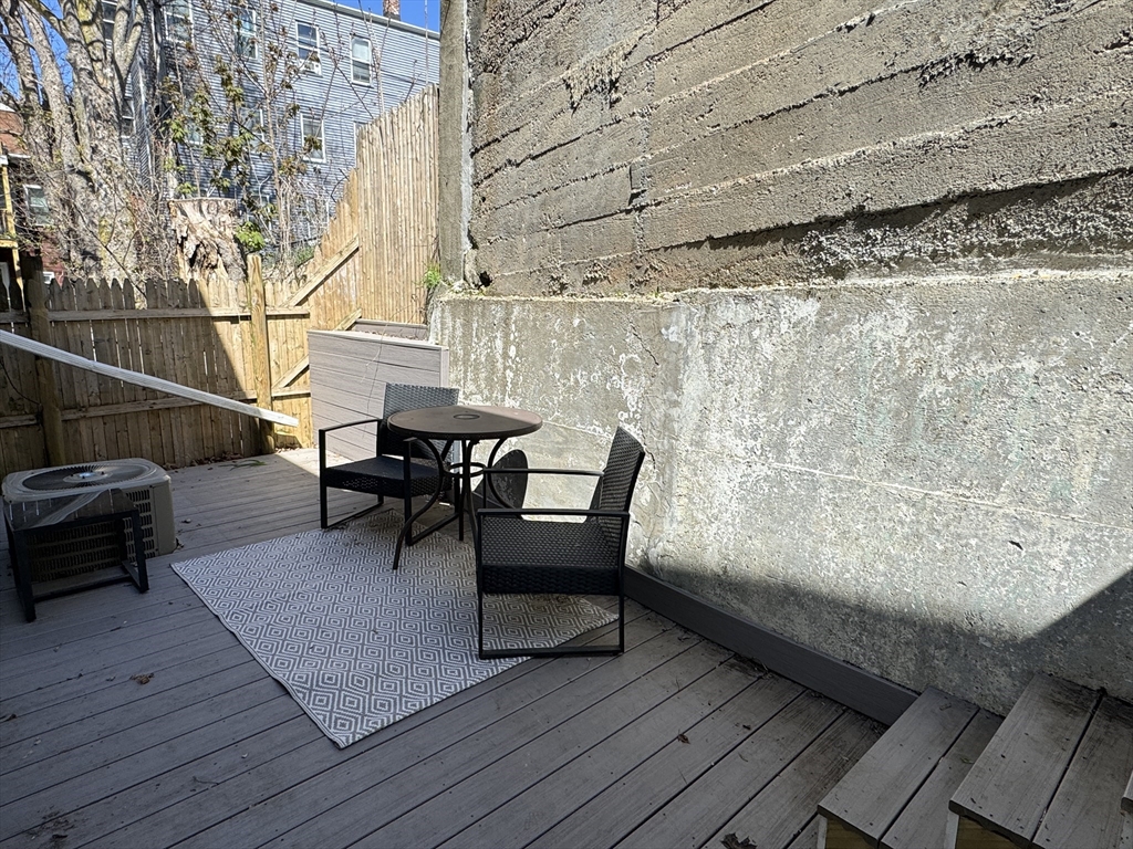 6 St James Place, Unit 6 Boston, MA 02119 - Photo 18 of 18 a balcony with wooden floor and glass door