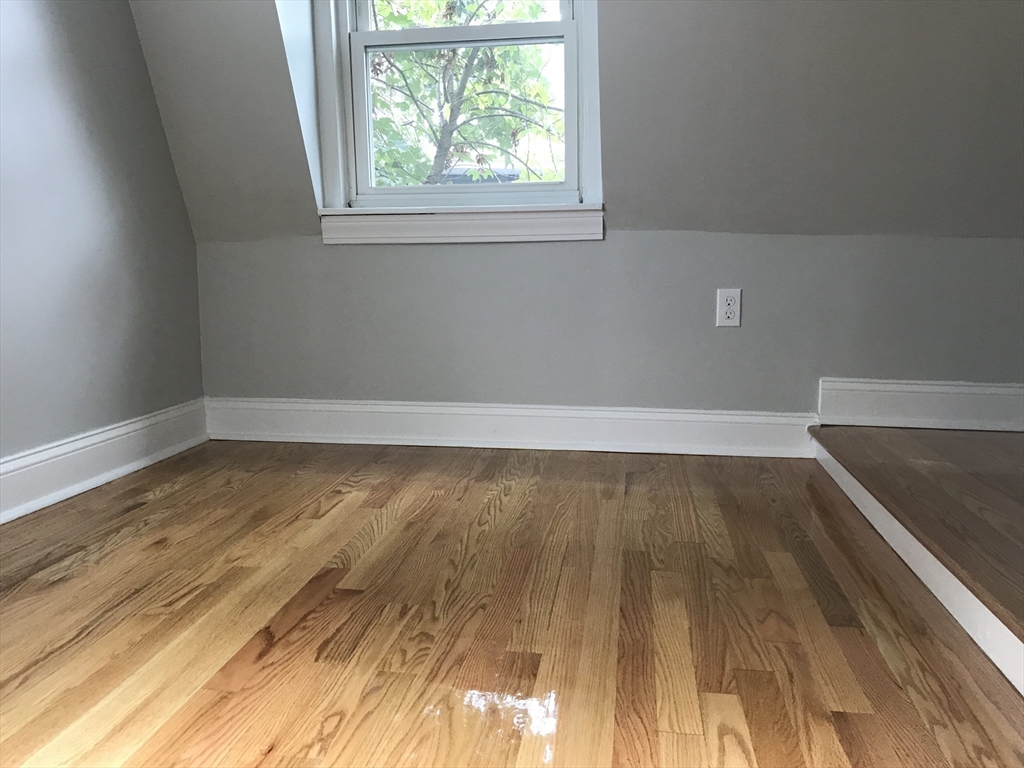 6 St James Place, Unit 6 Boston, MA 02119 - Photo 6 of 18 an empty room with wooden floor and windows