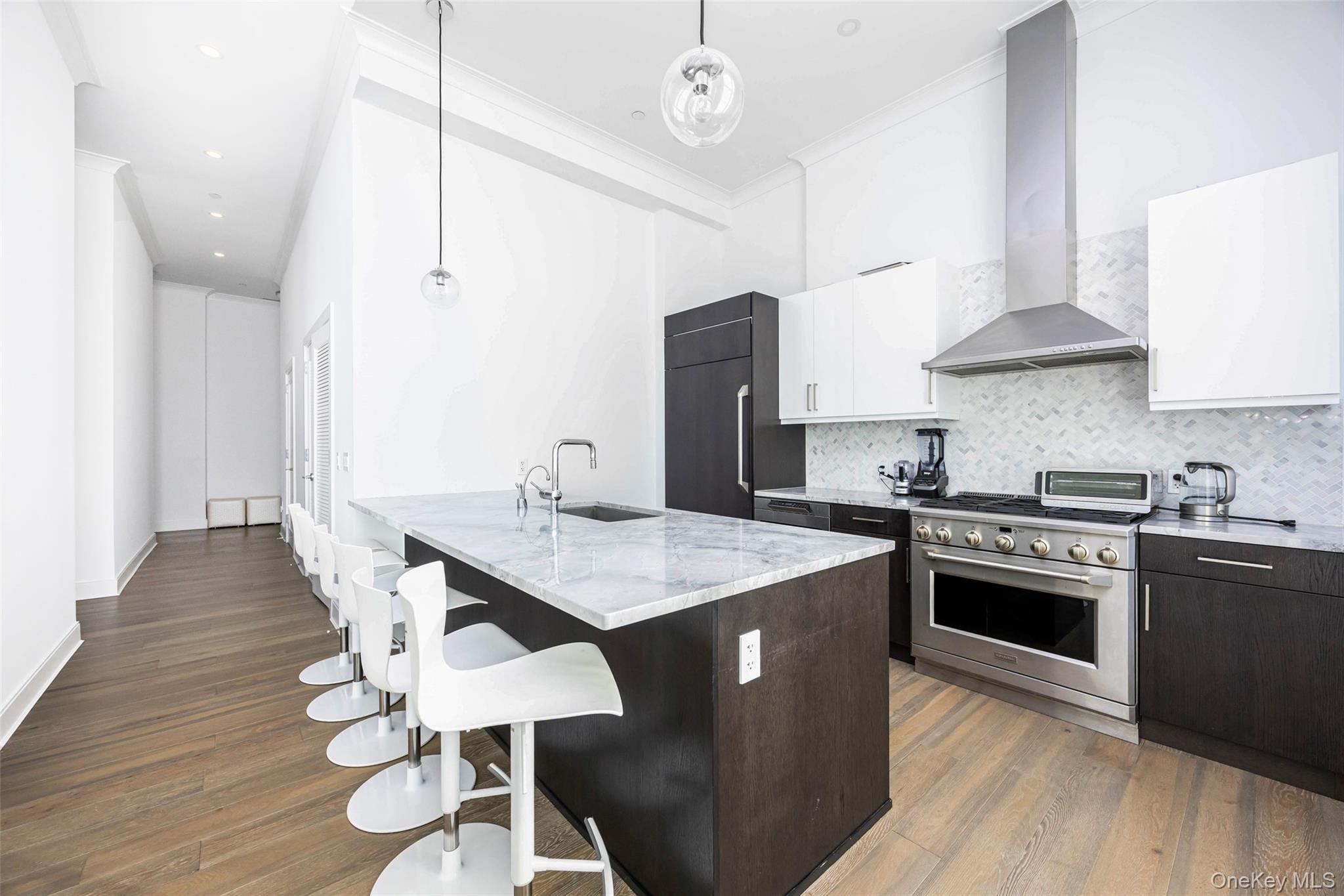 100 Garvies Point Road, Unit 1024 Glen Cove, NY 11542 - Photo 18 of 41 a kitchen with a stove a sink a dining table and chairs