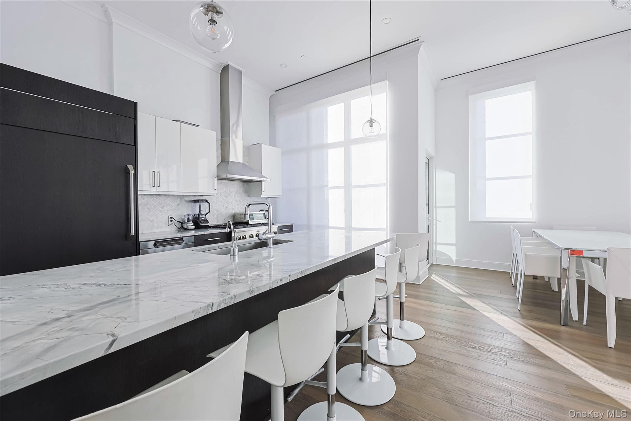 100 Garvies Point Road, Unit 1024 Glen Cove, NY 11542 - Photo 29 of 41 a large kitchen with granite countertop a dining table chairs and a refrigerator