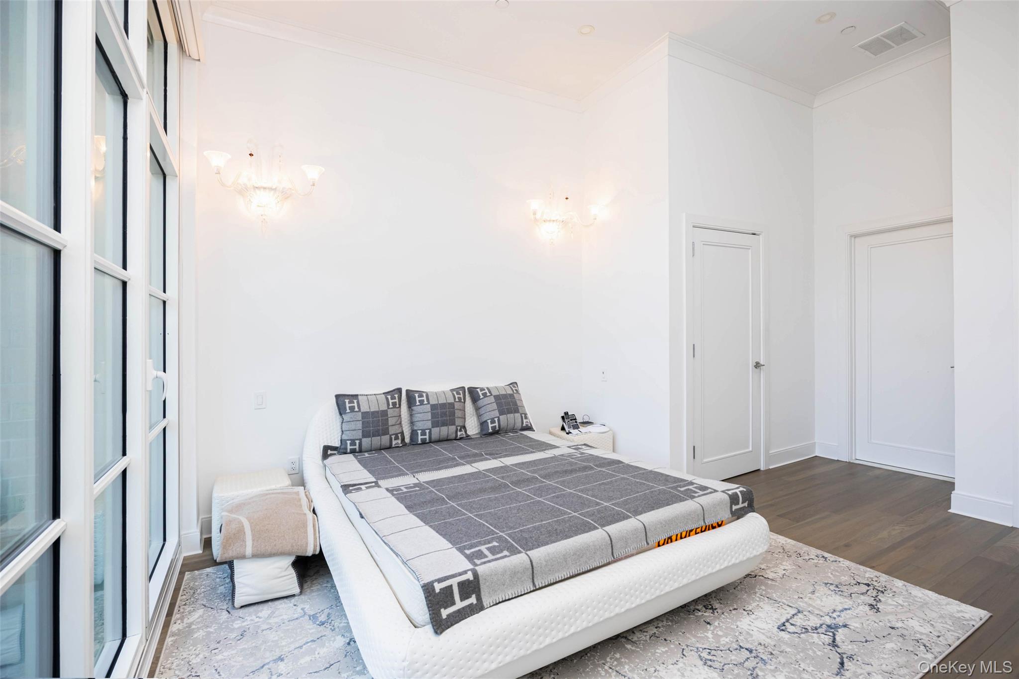 100 Garvies Point Road, Unit 1024 Glen Cove, NY 11542 - Photo 33 of 41 a bedroom with a bed and wooden floor