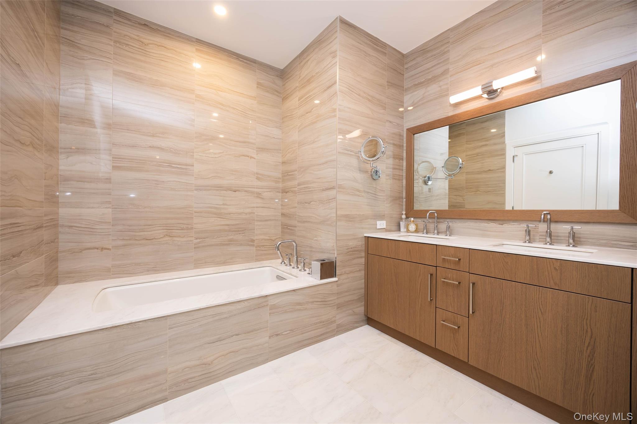 100 Garvies Point Road, Unit 1024 Glen Cove, NY 11542 - Photo 34 of 41 a spacious bathroom with a bathtub sink and mirror