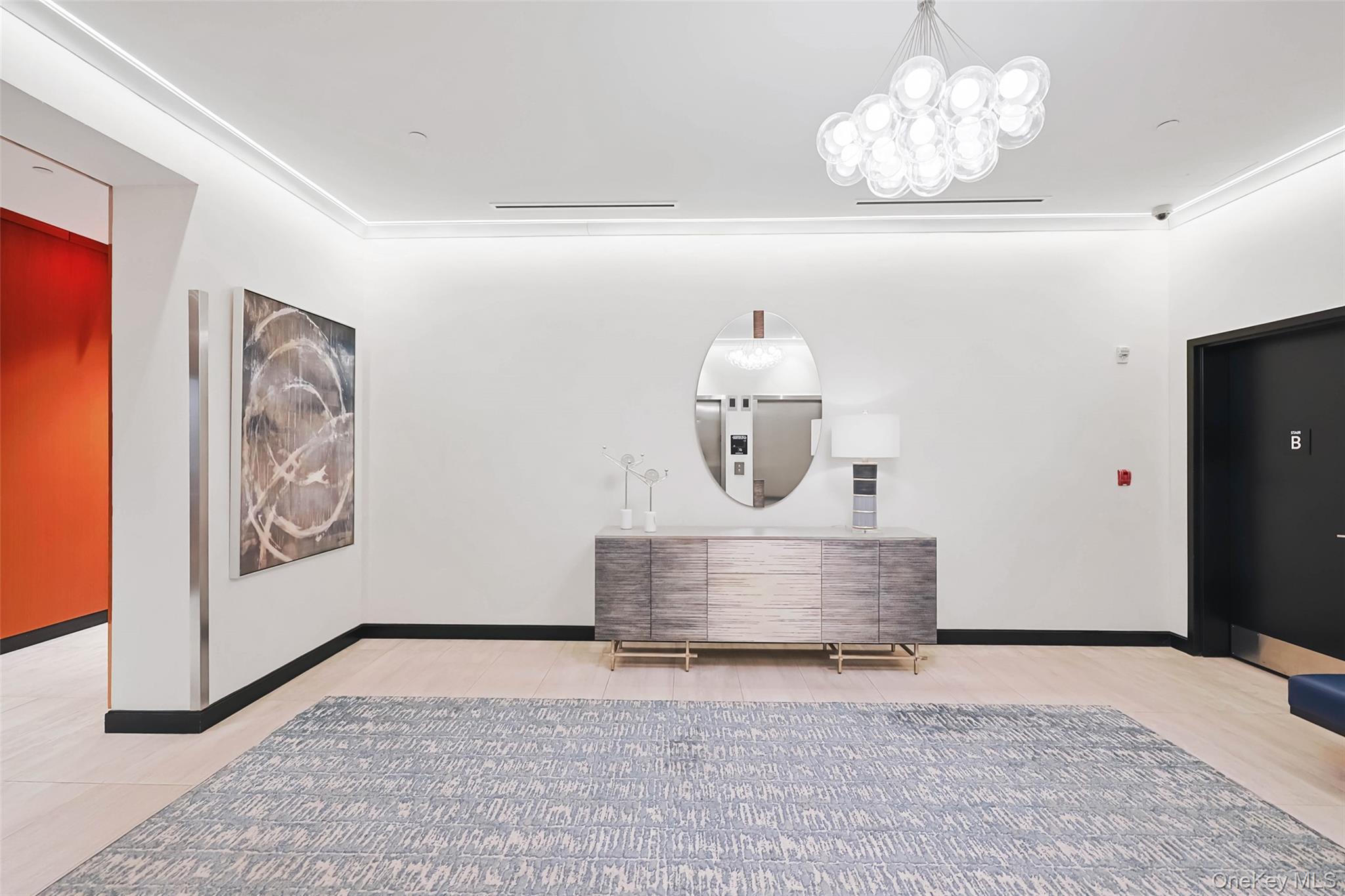 100 Garvies Point Road, Unit 1024 Glen Cove, NY 11542 - Photo 6 of 41 a view of a hallway with painting on the wall and a chandelier