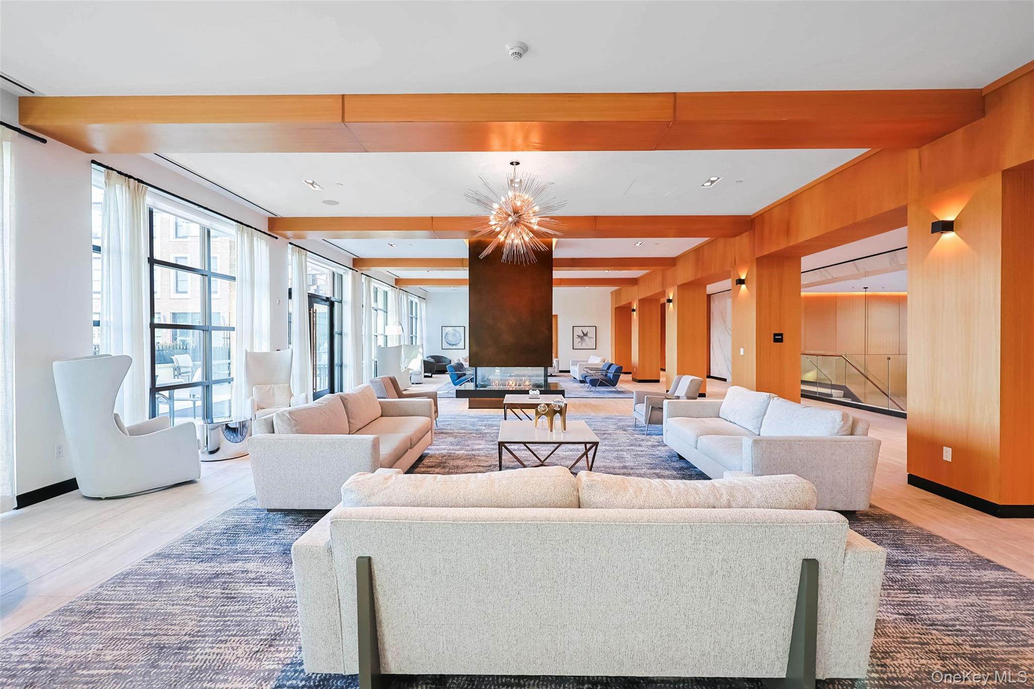 100 Garvies Point Road, Unit 1024 Glen Cove, NY 11542 - Photo 8 of 41 a large living room with furniture and large windows