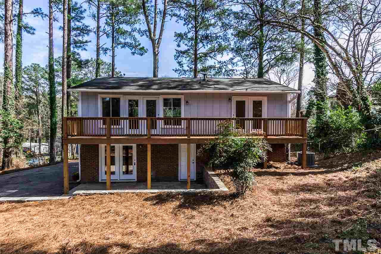 1237 Somerset Road Raleigh, NC 27610 - Photo 22 of 25 a view of a white house with large windows and a tree
