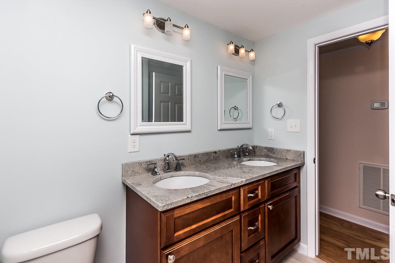 1237 Somerset Road Raleigh, NC 27610 - Photo 8 of 25 a bathroom with a granite countertop sink a toilet and a mirror