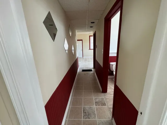 a hallway with wooden floor and stairs