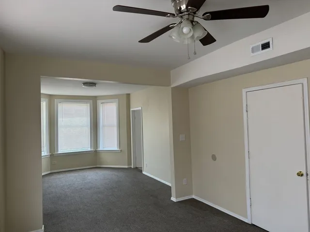 a view of an empty room with a ceiling fan
