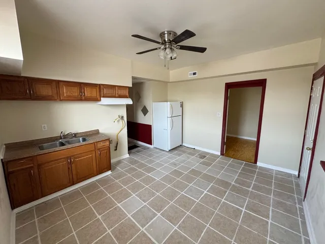a kitchen with stainless steel appliances granite countertop a sink and a refrigerator