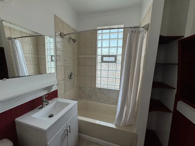 a bathroom with a tub sink a mirror and a shower