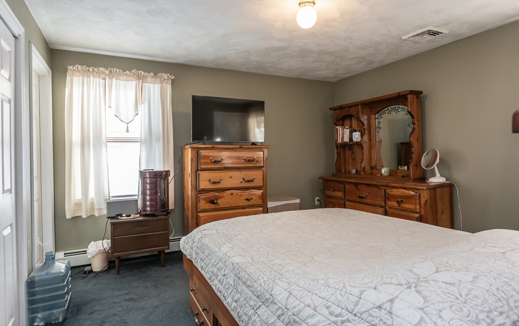 95 Hiatt Street Fall River, MA 02721 - Photo 14 of 22 a bedroom with a bed and dresser with mirror