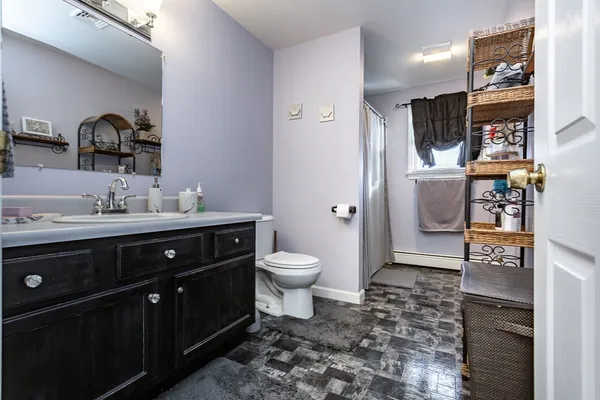 a bathroom with a toilet sink double vanity and mirror