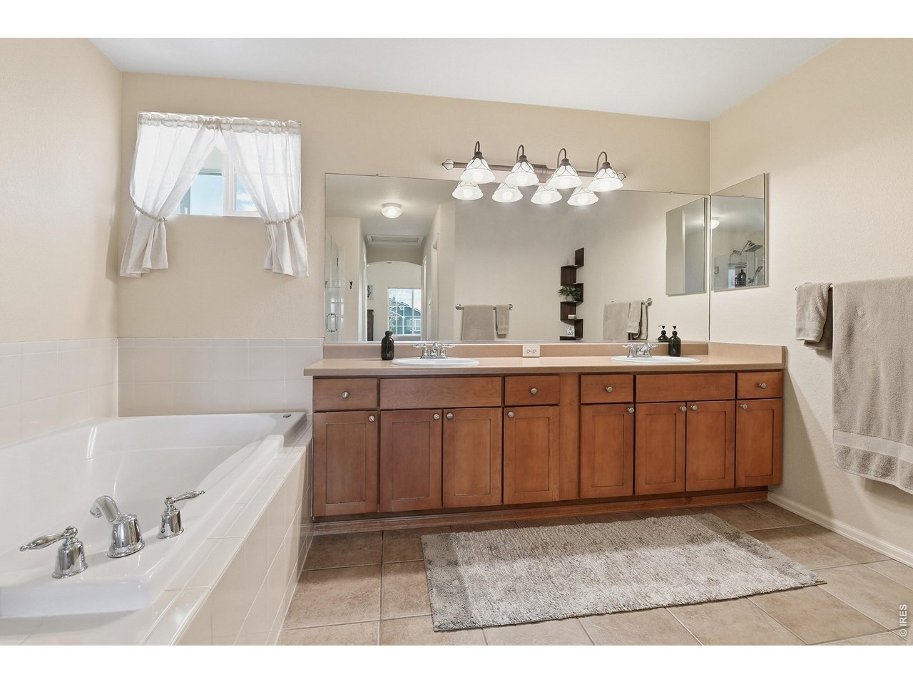 6291 Taylor Street Frederick, CO 80530 - Photo 20 of 50 a bathroom with a double vanity sink mirror and bathtub