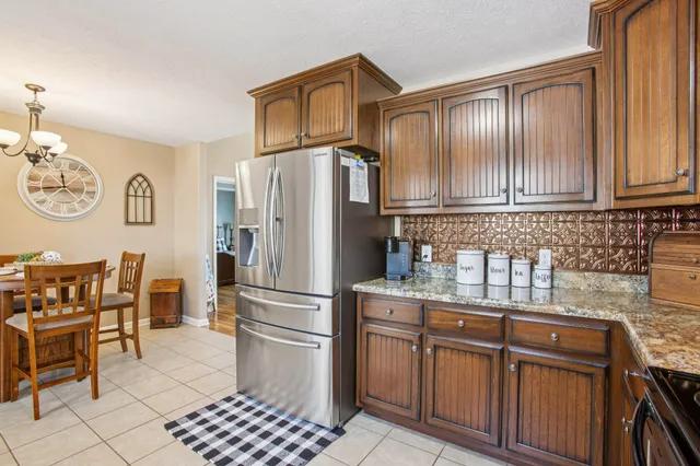 a kitchen with stainless steel appliances granite countertop a refrigerator and a stove top oven