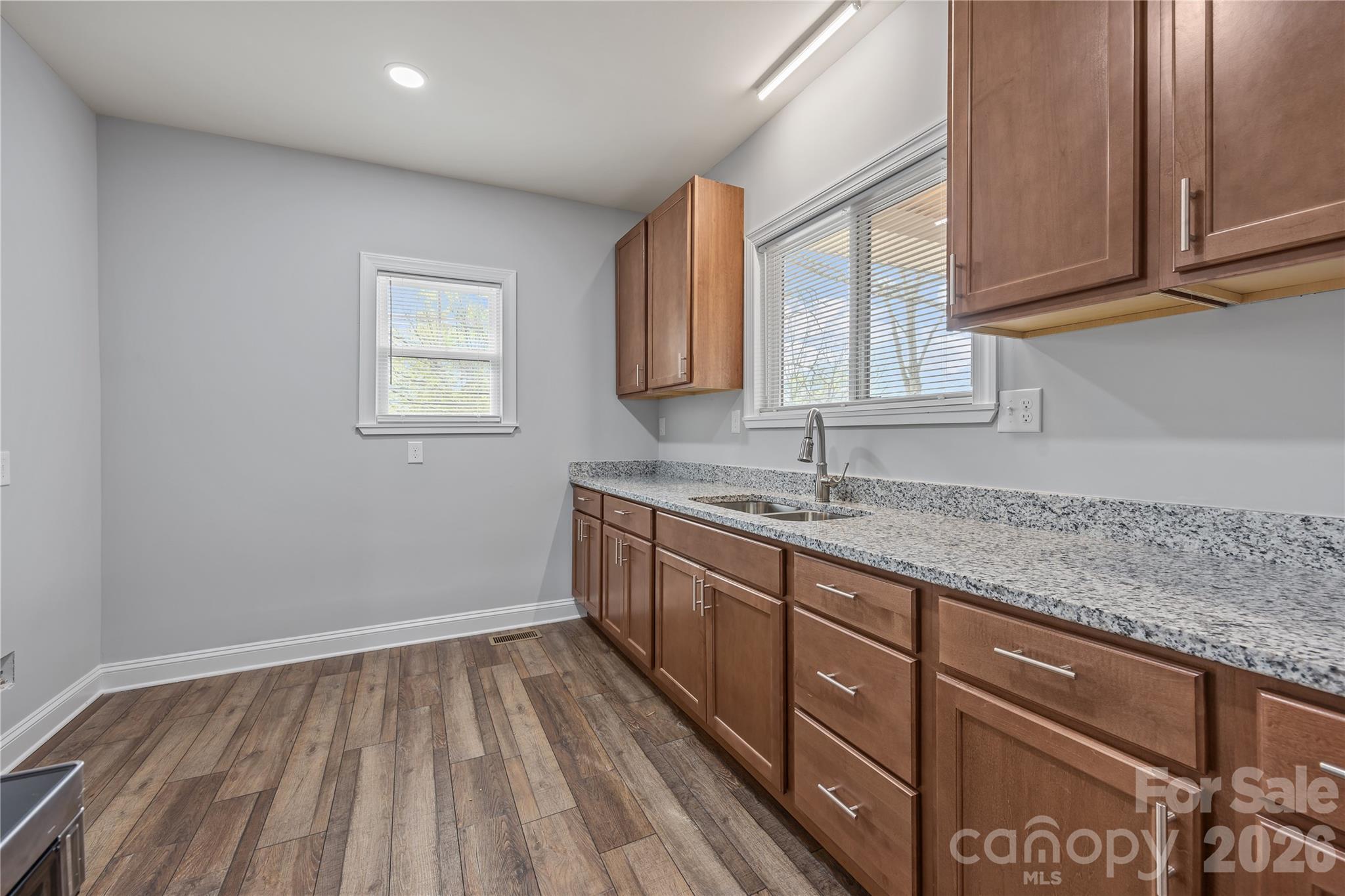 94 James Street Southwest Concord, NC 28025 - Photo 11 of 40 a kitchen with granite countertop wooden cabinets a sink and dishwasher