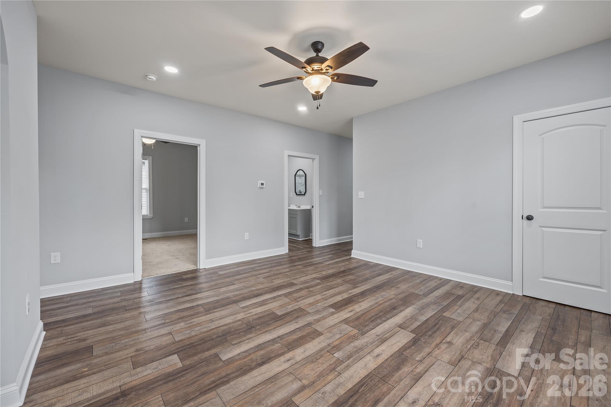 94 James Street Southwest Concord, NC 28025 - Photo 15 of 40 a view of an empty room with wooden floor and a ceiling fan