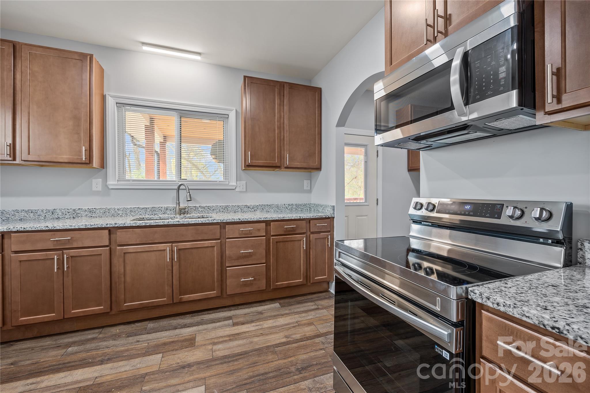94 James Street Southwest Concord, NC 28025 - Photo 9 of 40 a kitchen with stainless steel appliances granite countertop a stove microwave and sink
