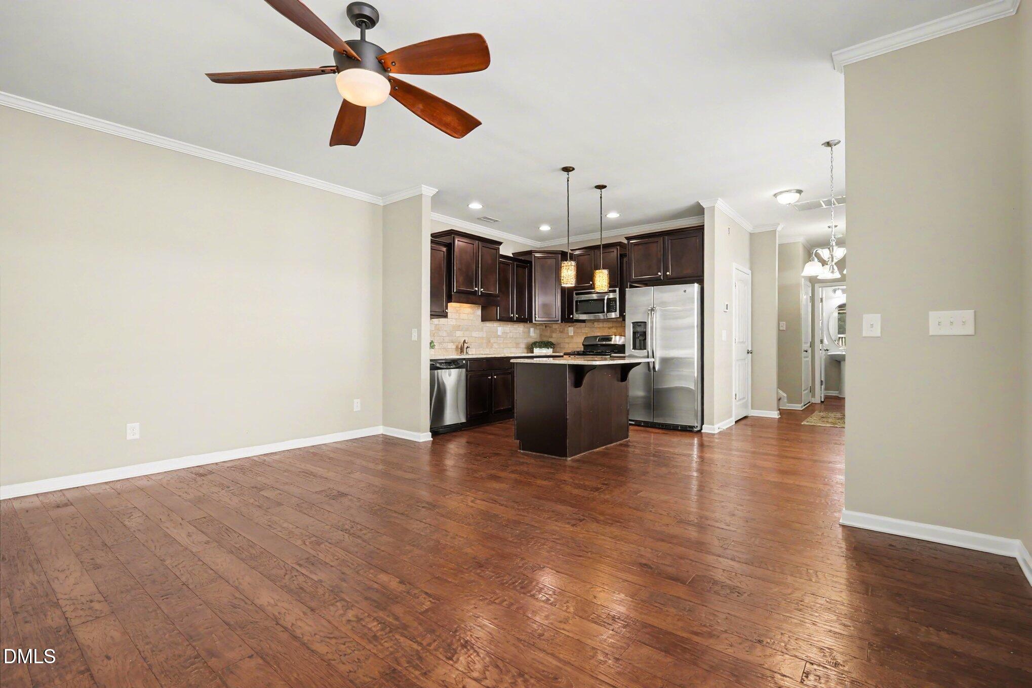 2409 Memory Ridge Drive Raleigh, NC 27606 - Photo 8 of 36 a view of kitchen with kitchen island stainless steel appliances a sink cabinets and wooden floor