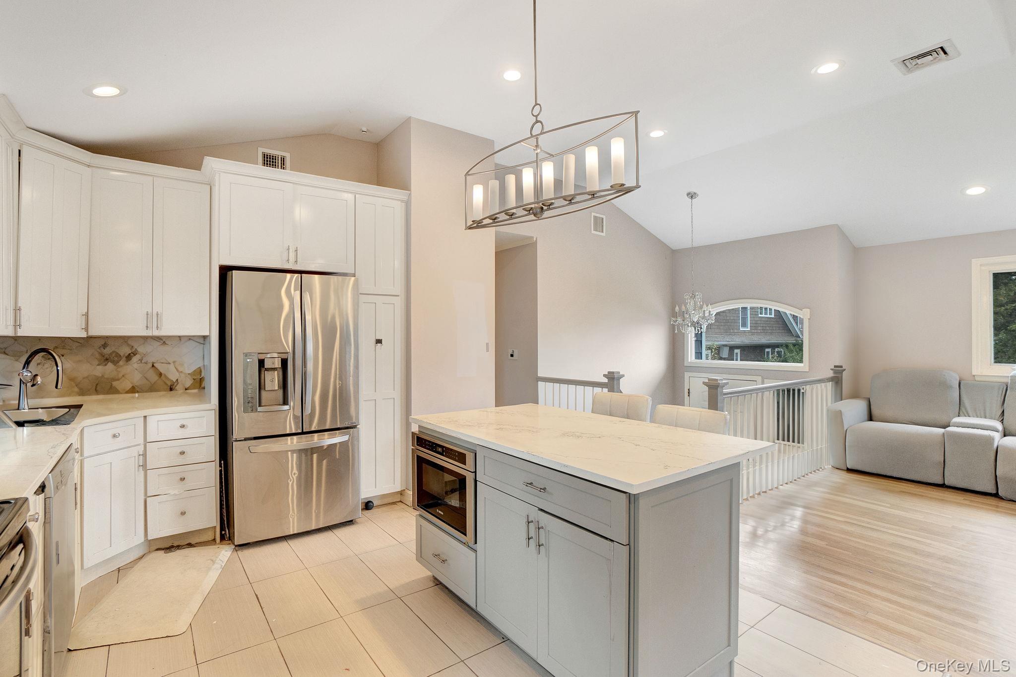 978 Little Whaleneck Road North Merrick, NY 11566 - Photo 10 of 32 Kitchen with vaulted ceiling, stainless steel appliances, tasteful backsplash, white cabinetry, and pendant lighting