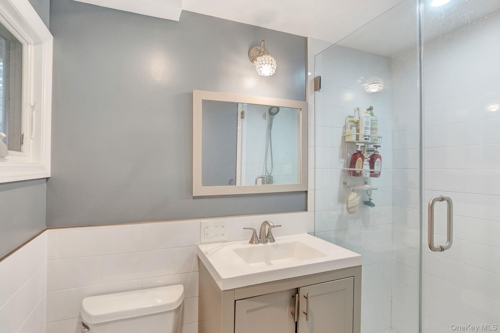 978 Little Whaleneck Road North Merrick, NY 11566 - Photo 13 of 32 Full bathroom featuring vanity, a shower stall, and tile walls
