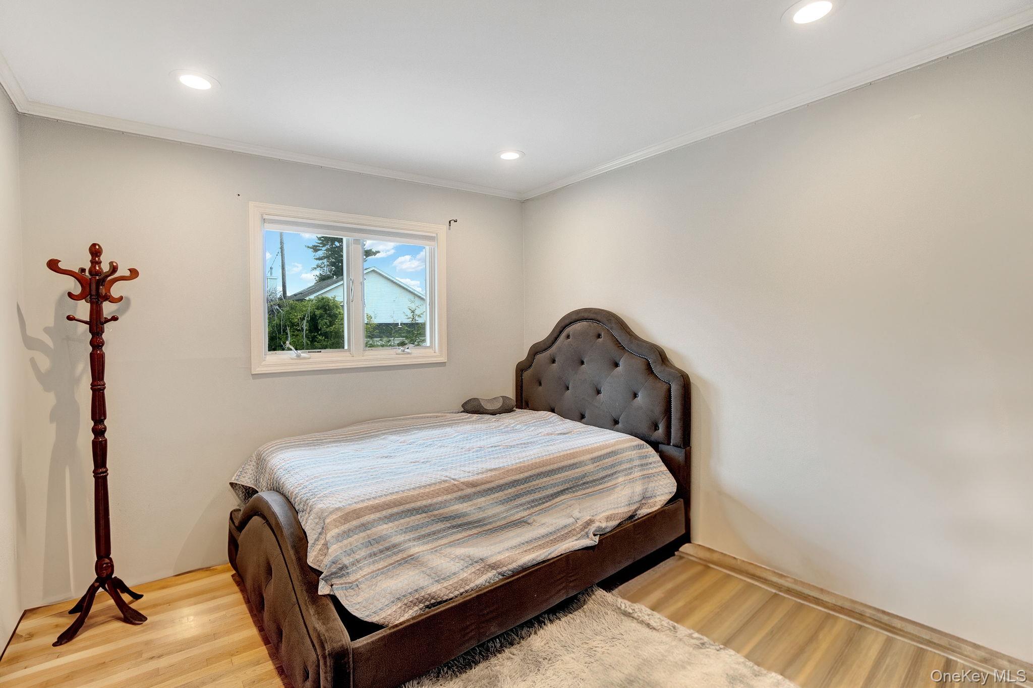 978 Little Whaleneck Road North Merrick, NY 11566 - Photo 14 of 32 Bedroom with wood finished floors, ornamental molding, and recessed lighting