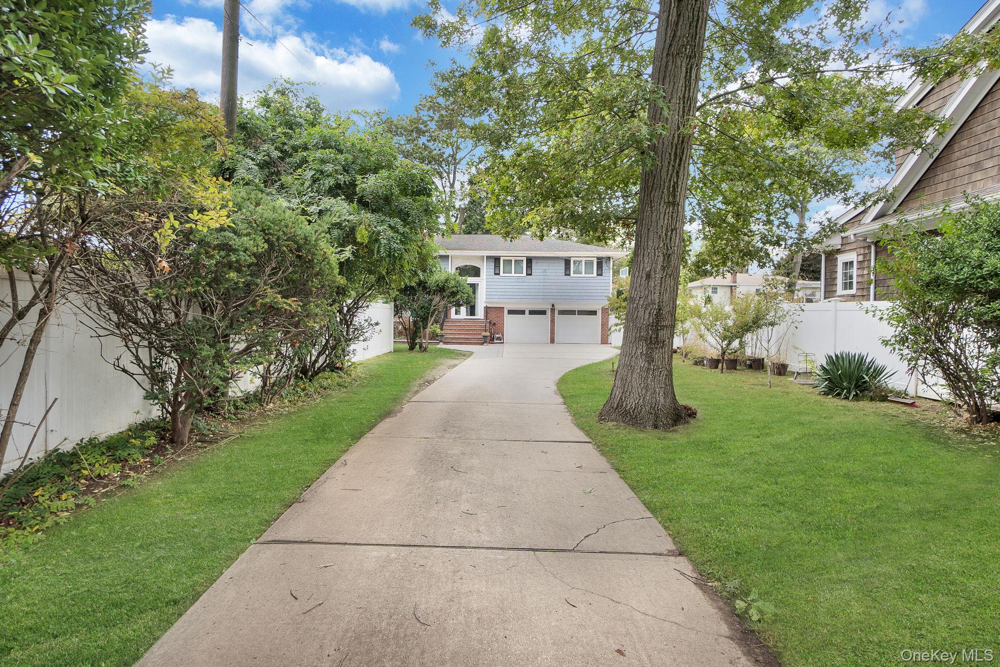 978 Little Whaleneck Road North Merrick, NY 11566 - Photo 2 of 32 View of front facade featuring driveway and an attached garage