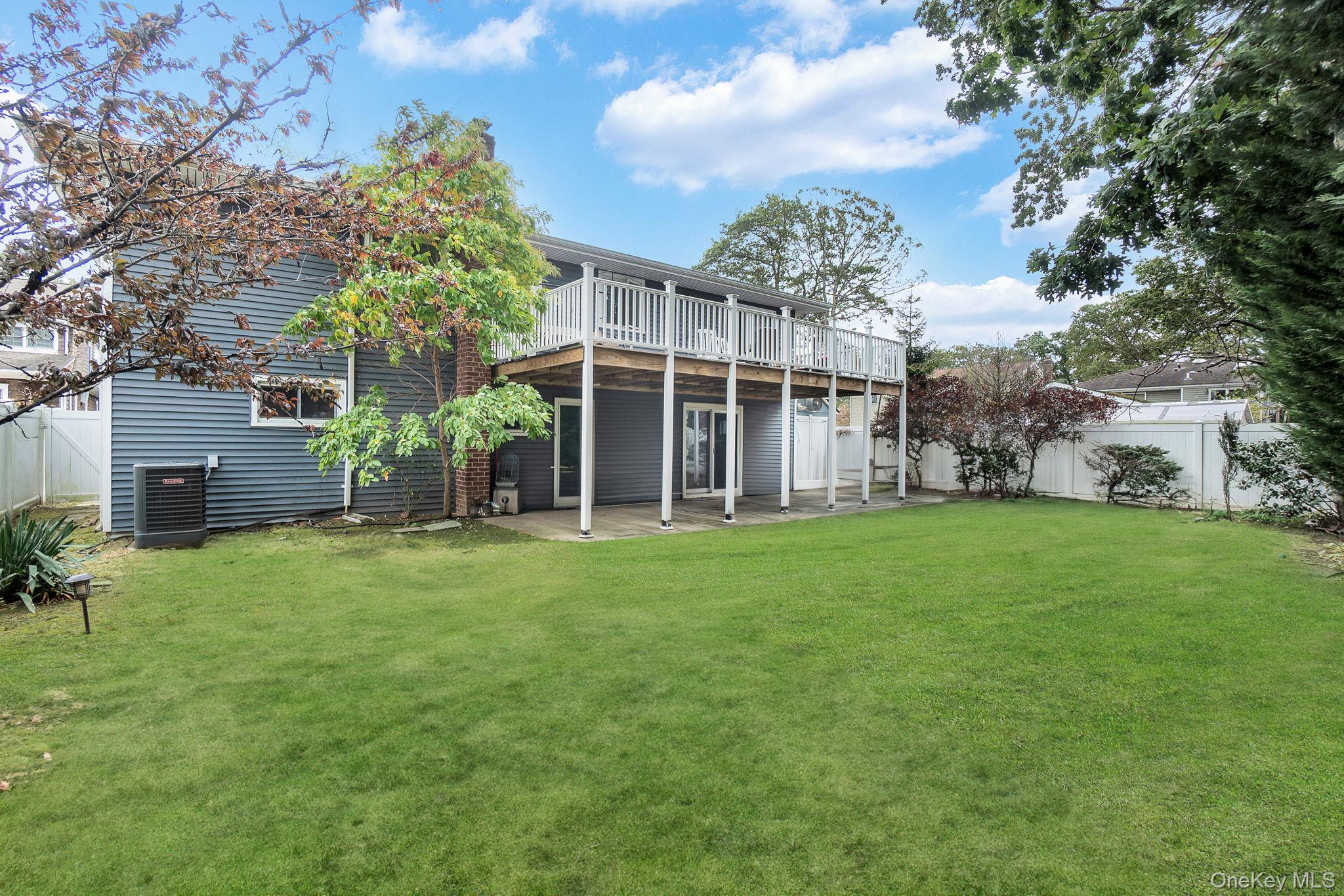 978 Little Whaleneck Road North Merrick, NY 11566 - Photo 30 of 32 Back of property featuring a fenced backyard, a deck, and a patio